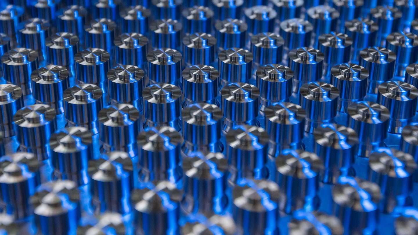 Präzisionsbauteile aus Metall für Wasserstofftechnologie in blauer Beleuchtung